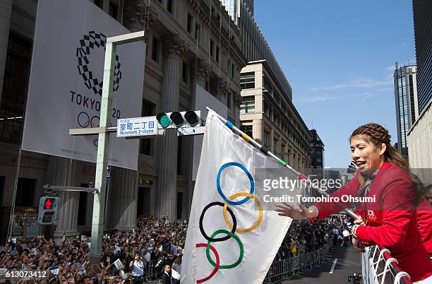 Japan's Rio de Janeiro Olympic team captain Saori Yoshida waves the Olympic flag from the top of a double decker bus as it passes through the...