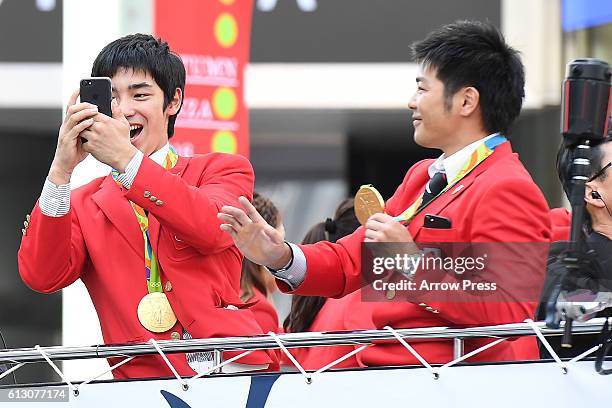 Kenzo Shirai and Koji Yamamuro take pictures on the top of a double decker bus during the Rio Olympic Paralympic 2016 Japanese medalist parade in the...