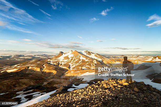 hiker looks across hveradalir to distant mountains - kerlingarfjoll fotografías e imágenes de stock