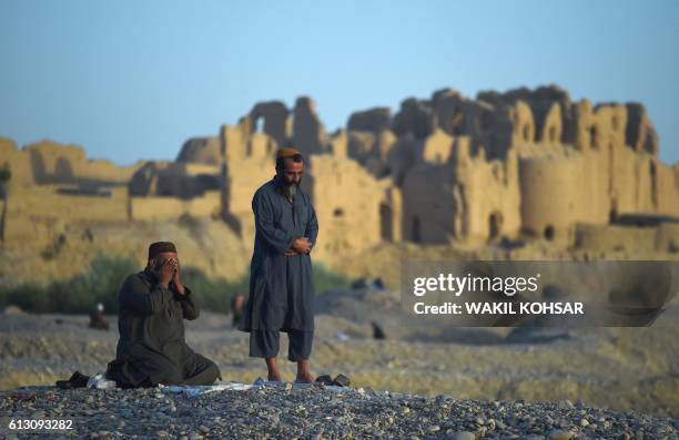 In this photograph taken on October 6, 2016 Afghan men offer prayers in Lashkar Gah of Helmand province.