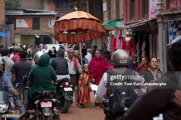 The Kumari priest and his wife escort Jibika Bajracharya, the newly appointed child goddess Kumari, through crowded streets on October 7, 2016 in...