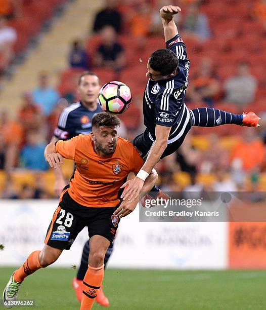 Brandon Borrello of the Roar and Daniel Georgievski of the Victory challenge for the ball during the round one A-League match between the Brisbane...