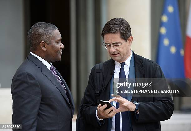 Nigerian businessman and Africa's richest man Aliko Dangote speaks with French General Director of the Banque Publique d'Investissement Nicolas...