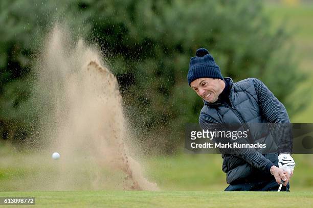 Actor Matthew Goode plays out from the bunker on the 11th hole during the second round of the Alfred Dunhill Links Championship on the Championship...