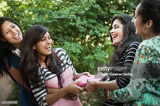 group of girl students playing tug of war with books. - four people stock pictures, royalty-free photos & images