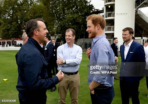 Former England cricket player Graeme Swann chats with Prince Harry during an event to mark the expansion of the Coach Core sports coaching...