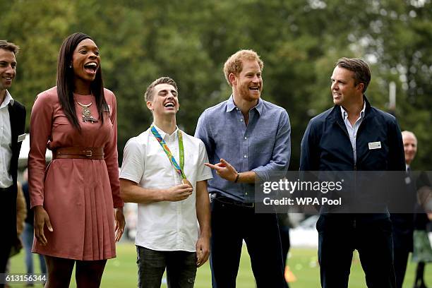 Prince Harry jokes with photographers as he poses in a group photograph with England netball player Eboni Beckford-Chambers, double-Olympic gold...