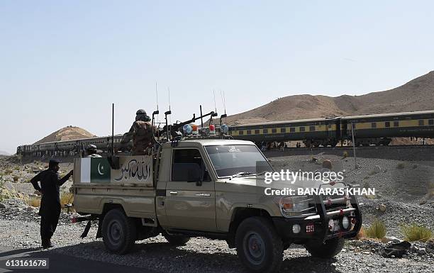 Pakistani soldiers look on near a train at the site of two explosions in the town of Much, 55 kilometres east of Balochistan's provincial capital...