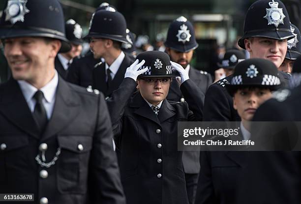 Female police cadet straightens her hat before the start of the Metropolitan Police 'Passing Out Parade' outside Peel House at Hendon Police College...