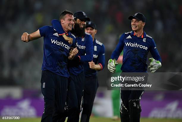 Jake Ball of England celebrates with Moeen Ali and captain Jos Buttler after taking the final wicket of Taskin Ahmed of Bangladesh to win the 1st One...