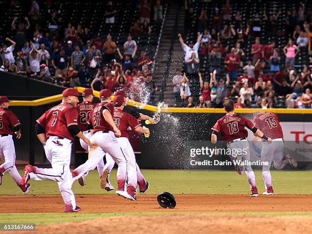 Phil Gosselin of the Arizona Diamondbacks is showered with water by his teammates after a walk-off single in the ninth inning of the MLB game against...