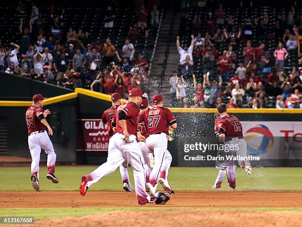 Phil Gosselin of the Arizona Diamondbacks is showered with water by his teammates after a walk-off single in the ninth inning of the MLB game against...