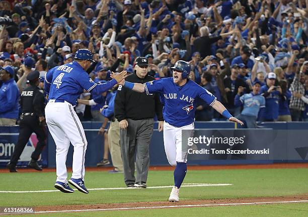 Josh Donaldson of the Toronto Blue Jays celebrates with third base coach Luis Rivera as he scores on a three-run walk-off home run hit by Edwin...