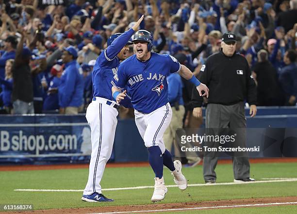 Josh Donaldson of the Toronto Blue Jays celebrates with third base coach Luis Rivera as he scores on a three-run walk-off home run hit by Edwin...