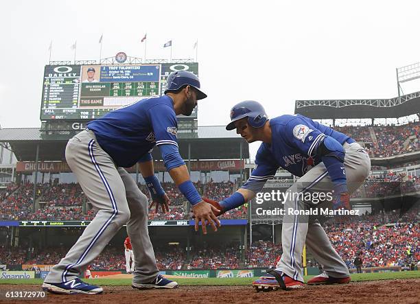 Troy Tulowitzki of the Toronto Blue Jays celebrates with Jose Bautista after hitting a home run against the Texas Rangers in the second inning of...