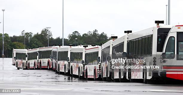 Disney World transport buses sit in an empty parking lot after its theme parks closed due to Hurricane Matthew, on October 7, 2016. Disney and the...
