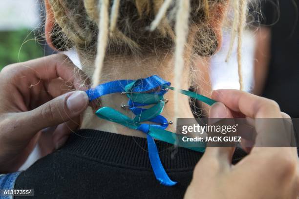 Piercer ties a ribbon, to form a corset, through the nape piercings of an Israeli woman during the 4th Israel Tattoo Convention in the coastal city...
