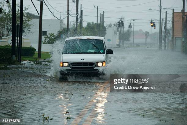 Vehicle drives through water near the Halifax River, October 7, 2016 in Daytona Beach, Florida. With Hurricane Matthew approaching the Atlantic coast...