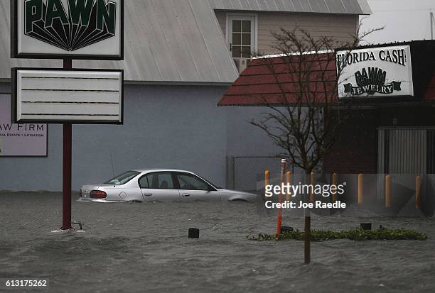 Car is seen in a flooded parking lot as Hurricane Matthew passes through the area on October 7, 2016 in St Augustine, Florida. Florida, Georgia,...