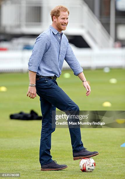 Prince Harry plays football as he attends an event to mark the expansion of the Coach Core sports coaching apprenticeship programme at Lord's cricket...