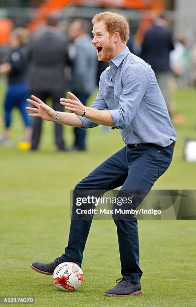 Prince Harry plays football as he attends an event to mark the expansion of the Coach Core sports coaching apprenticeship programme at Lord's cricket...