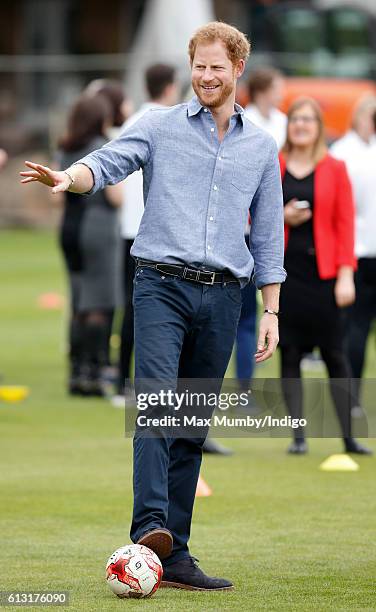 Prince Harry plays football as he attends an event to mark the expansion of the Coach Core sports coaching apprenticeship programme at Lord's cricket...