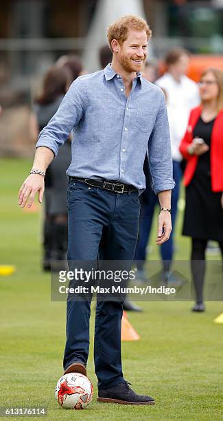 Prince Harry plays football as he attends an event to mark the expansion of the Coach Core sports coaching apprenticeship programme at Lord's cricket...