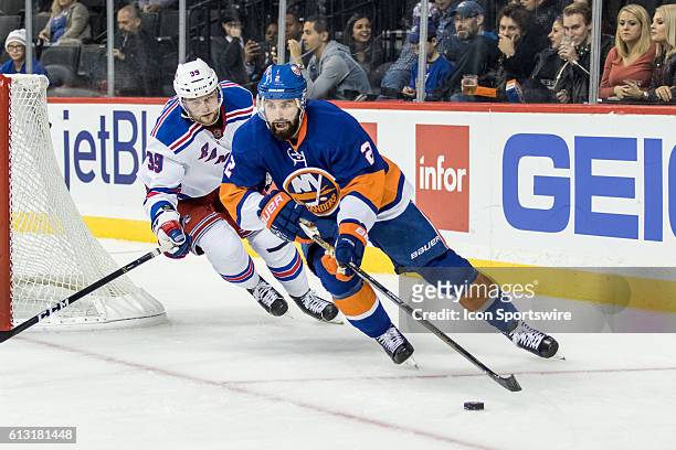 New York Rangers Left Winger Nicklas Jensen chases New York Islanders Defenseman Nick Leddy out from behind the Islanders net during the third period...