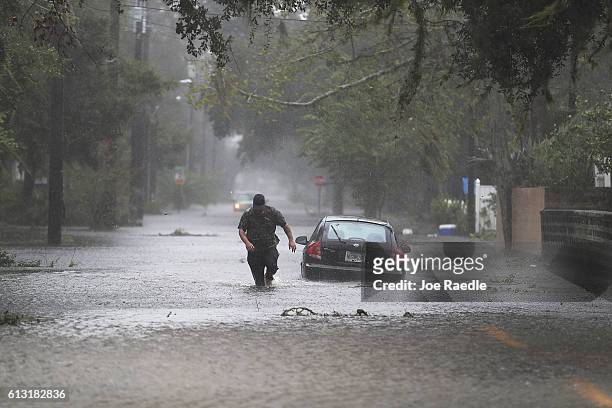 Justin Dossett walks through a flooded street as Hurricane Matthew passes through the area on October 7, 2016 in St Augustine, Florida. Florida,...
