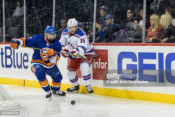 New York Islanders Defenseman Nick Leddy and New York Rangers Left Winger Nicklas Jensen chase after the puck during the third period of a preseason...