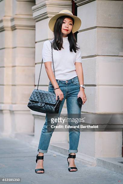 May Berthelot , is wearing a Maison Michel yellow hat, a Courreges white turtleneck top, The Kooples blue denim boyfriend jeans, H&M sandals, and a...