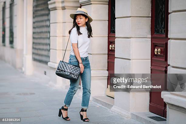 May Berthelot , is wearing a Maison Michel yellow hat, a Courreges white turtleneck top, The Kooples blue denim boyfriend jeans, H&M sandals, and a...