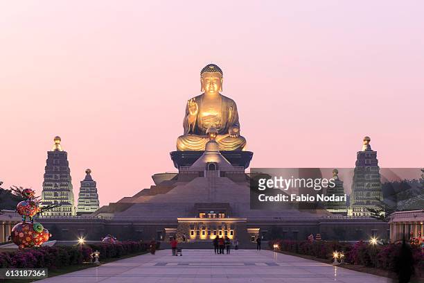 sunset at fo guang shan buddist temple of kaohsiung, taiwan with many tourists walking by. - kaohsiung taiwan stockfoto's en -beelden