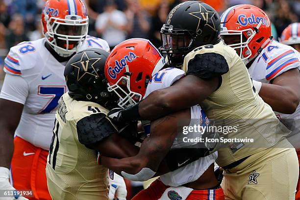 Vanderbilt Commodores inside linebacker Zach Cunningham and defensive tackle Adam Butler make a tackle during a 13-6 win by Florida over Vanderbilt...