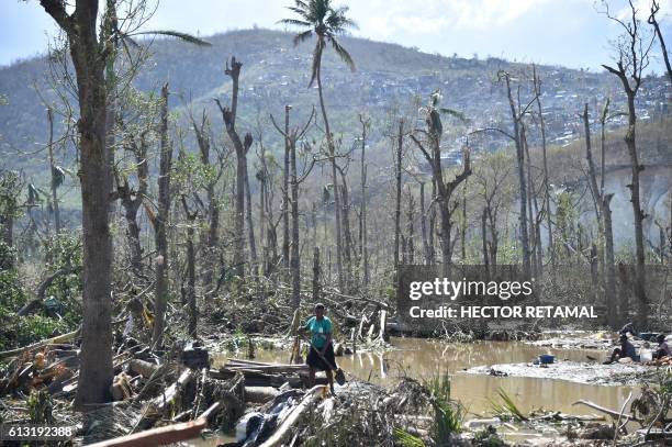 Woman cleans the area where her house stood but was destroyed in hurricane Matthew, in Jeremie, in western Haiti, on October 7, 2016. The full scale...