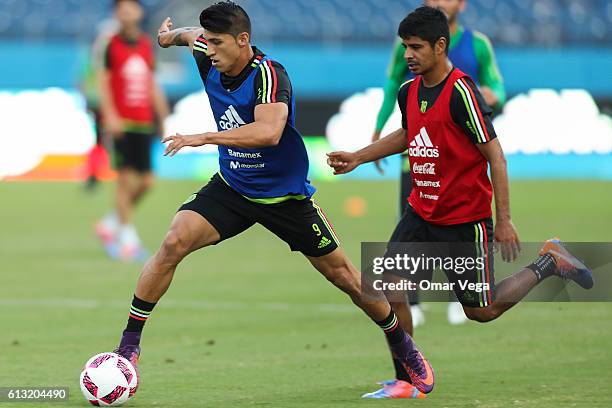 Alan Pulido of Mexico drives the ball as followed by teammate Luis Robles during a training session at Nissan Stadium on October 07, 2016 in...