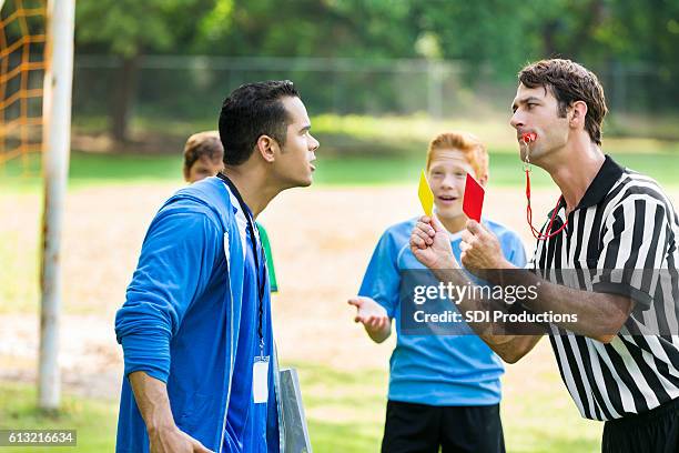 soccer coach argues with referee about penalty call - referee stripes stock pictures, royalty-free photos & images