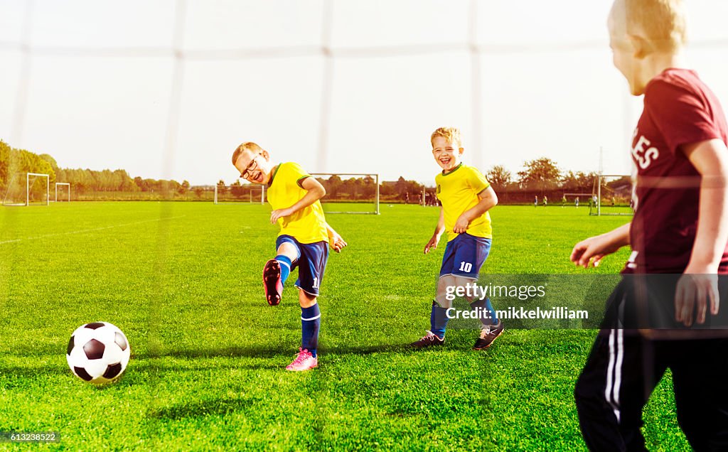 Soccer player shoots goal while playing with his football team