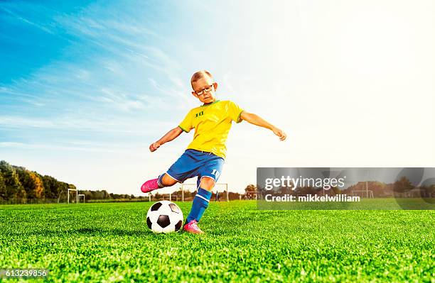 junge spielt fußball auf dem feld und kickt fußball - 6 football player stock-fotos und bilder