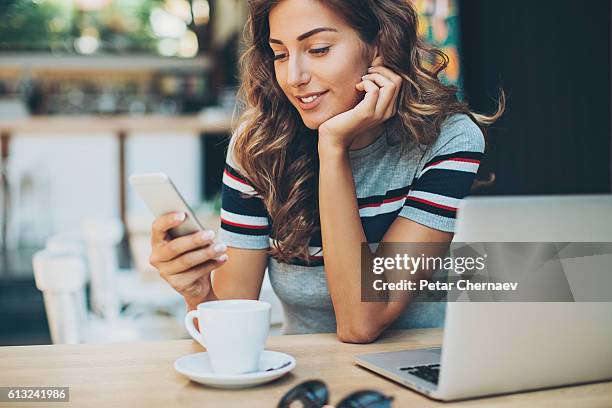 beautiful girl with smart phone in cafe - girl and coffee stockfoto's en -beelden