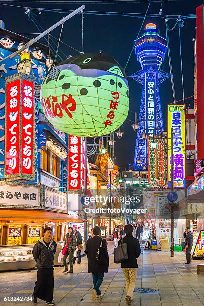 osaka neon nacht tsutenkaku turm mit blick auf die menschen in shinsekai japan - osaka shinsekai food stock-fotos und bilder