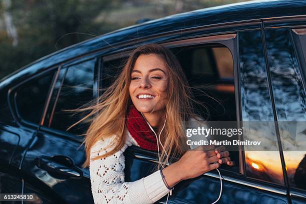 teenage girl looking out of the car window - car listening to music imagens e fotografias de stock