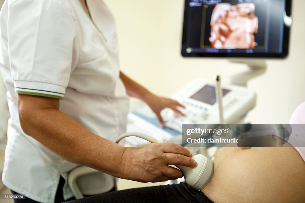 Doctor performing ultrasound on a pregnant woman