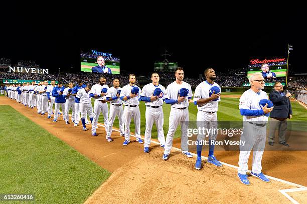 Members of the Chicago Cubs are seen on the base path during the singing of the national anthem prior to Game 1 of NLDS against the San Francisco...