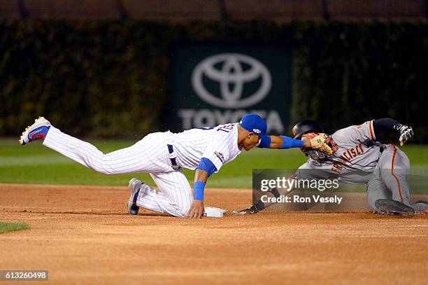 Addison Russell of the Chicago Cubs tags out Gorkys Hernandez of the San Francisco Giants as attempts to steal second base in the first inning of...