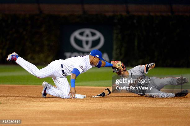 Addison Russell of the Chicago Cubs tags out Gorkys Hernandez of the San Francisco Giants as attempts to steal second base in the first inning of...