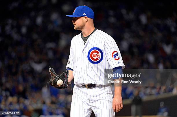 Jon Lester of the Chicago Cubs reacts to getting the final out of the sixth inning after the ball got stuck in the webbing of his glove during Game 1...