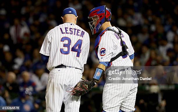 Jon Lester of the Chicago Cubs talks with David Ross in the fifth inning against the San Francisco Giants at Wrigley Field on October 7, 2016 in...