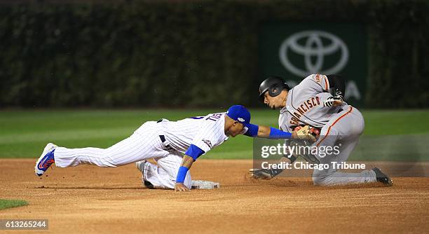 Chicago Cubs shortstop Addison Russell, left, tags out the San Francisco Giants' Gorkys Hernandez as he tries to steal second base in the first...