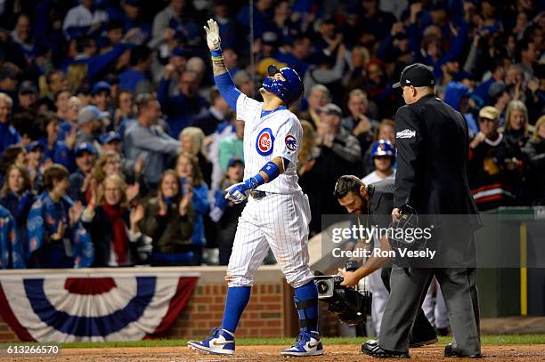 Javier Baez of the Chicago Cubs points to the sky after crossing home plate after hitting a solo home run in the eighth inning during Game 1 of NLDS...